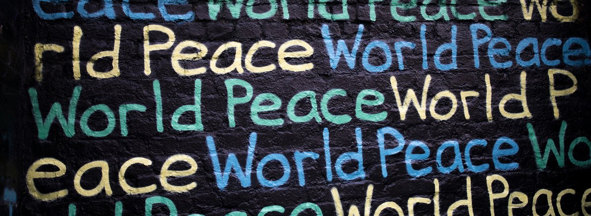 Decorative element: World Peace written in different colours on a black wall