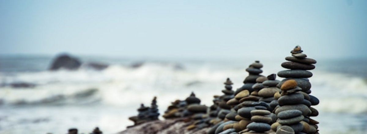 Decorative element: Stones and pebbles balanced in towers near the water at a beach