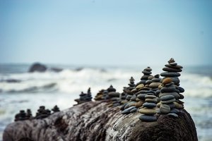 Decorative element: Stones and pebbles balanced in towers near the water at a beach